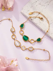 Detail von luxuriösem Gold-Edelstahlschmuckset mit grünen und opalen Katzenaugen-Steinen
