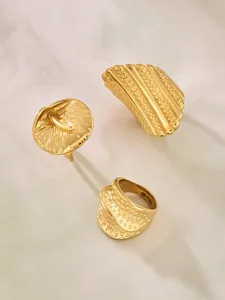 Detailaufnahme vergoldeter Edelstahlringe mit ACIER-Gravur und gehämmerter Textur