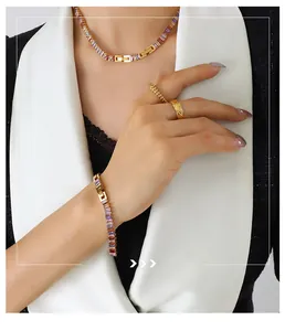 Detail view of gold-plated jewelry set with colorful zircons and quilted texture design