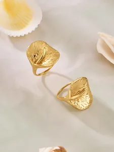 Detail von 18k vergoldeten Edelstahlringen mit strukturiertem Blütenblatt auf Marmor