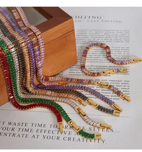 Close-up of colorful baguette-cut zircon necklaces and bracelets on wooden box