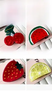 Detailed view of four acetate fruit hair claws including cherry and lemon patterns