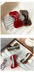 Detail of red and tortoiseshell heart-shaped bow hair combs with metal teeth set