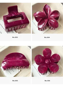 Dettaglio di quattro fermagli per capelli viola prugna con trama marmorea su carta beige