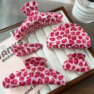 Pink leopard pattern acetate hair claw clip set displayed on a velvet jewelry tray