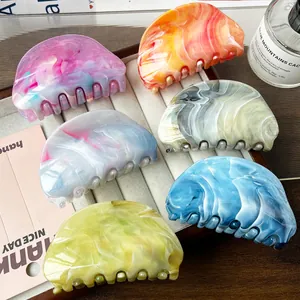 Set of 6 oval marble pattern acetate hair claws for women displayed on velvet tray