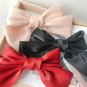Lot de trois barrettes à nœud en satin rose, noir et rouge avec fini perlé chic