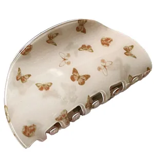 Brown butterfly hair claw clip in faux acetate finish on a clean white background