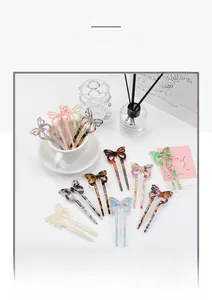 Detail of tortoise shell and marble acetate butterfly hair forks in a ceramic cup
