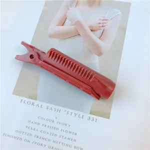 Detail of dark red plastic hair root clip with comb teeth design for volume styling