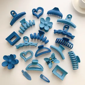 Detail view of Klein blue hair claws in heart, flower, and geometric shapes with matte finish