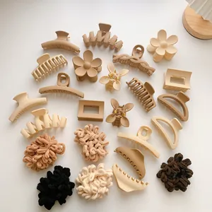 Assorted matte shark clips and plush scrunchies in minimalist neutral earth tones