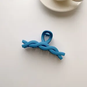 Detail of Klein blue matte hair claw clip featuring a braided design on white background