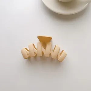 Macro detail of a large matte cream shark hair clip with wide wave-shaped teeth design