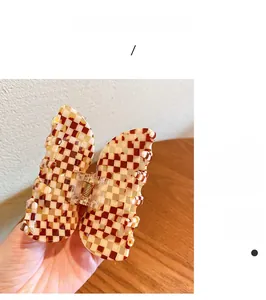 Detailansicht der schmetterlingsförmigen Haarklammer mit braunem Schachbrettmuster