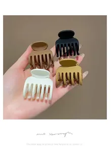 Dettaglio di quattro fermagli per capelli opachi per coda alta in toni neutri