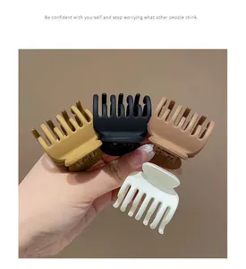 Dettaglio di quattro fermagli per coda di cavallo opachi in tonalità neutre della terra