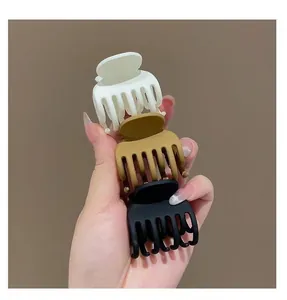 Dettaglio di mollette per capelli opache in plastica beige, kaki e nero