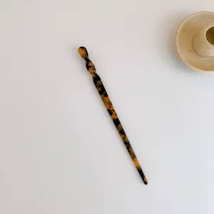 Detailansicht eines bernsteinfarbenen Haargabel aus Acetat mit gedrehtem Knotendesign