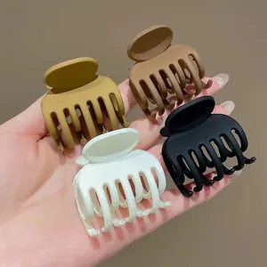 Set di quattro mollette opache per capelli in giallo, marrone, bianco e nero per donna