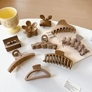 Set of 9 matte hair clips in earthy neutral tones with geometric and floral shapes