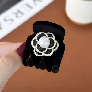 Eleganter schwarzer beflockter Haargreifer mit Kamelienblüte und Perlenverzierung