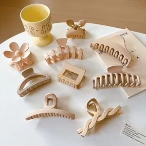 Eight pieces of matte cream hair claws in minimalist geometric shapes and floral designs