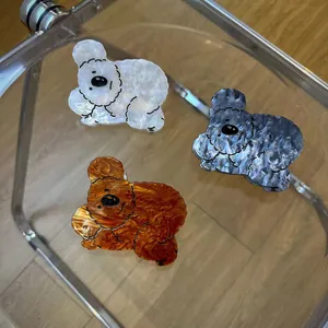 Dettaglio di tre mollette per capelli a forma di orso in acetato con venature marmoree