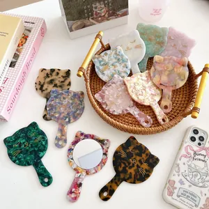 Cat-shaped handheld vanity mirrors made of acetate with colorful marble textures