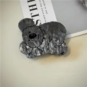 Dettaglio della molletta per capelli a cucciolo in acetato grigio marmo con sfondo elegante