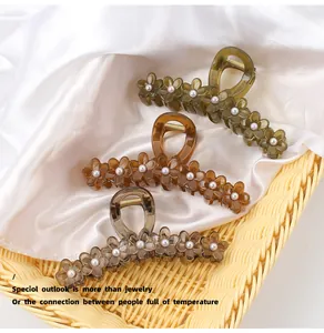 Detail of flower hair claws with pearls in amber, grey, and green colors in a basket