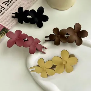 Matte floral hair clips in four vintage colors on a stylish white display tray