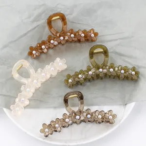 Floral resin hair claw clips in jelly colors with pearl accents on a marble tray