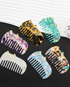 Close-up of cat-shaped acetate hair combs in various patterns like tortoiseshell and floral