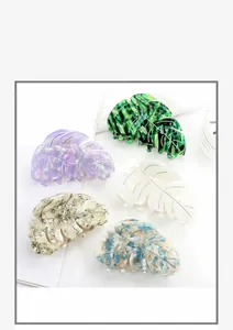 Flat lay of leaf-shaped acetate hair claws in various marble and pearlescent finishes