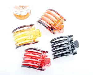 Détail de grandes pinces à cheveux multi-dents en ambre, jaune, rouge et noir brillant