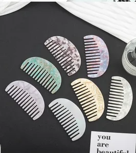Set of seven colorful acetate crescent-shaped wide-tooth combs with marble texture