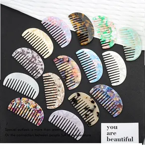 Flat lay of 14 acetate hair combs in various marble patterns on black background