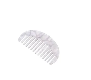 Macro detail of crescent acetate hair comb with wide teeth and purple marble texture