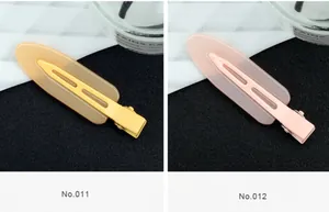 Gros plan de barrettes en acrylique jaune et rose avec base en métal crocodile