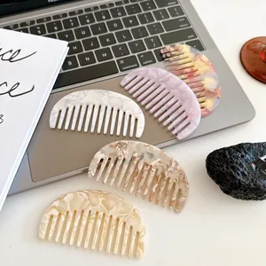 5-piece acetate marble pattern half-moon hair combs set on a laptop desk