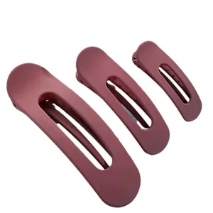 Juego de tres pinzas para el cabello color malva mate en varios tamaños sobre blanco