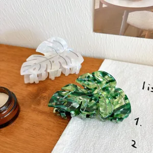 Elegant monstera leaf hair claws in pearl white and marble green acetate material