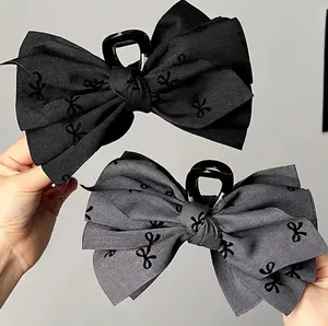 Large fabric bow hair claw clips in black and grey with small butterfly patterns