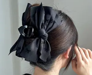 Detail of a large black fabric bow hair claw clip for elegant women hairstyles