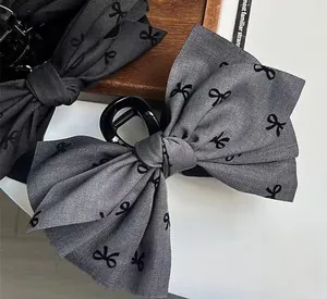 Detail of fabric bow hair claws in black and grey pattern for elegant styling