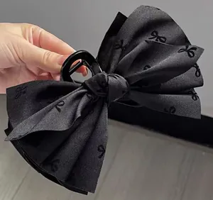 Detailed view of the large black fabric bow hair claw clip with jacquard patterns
