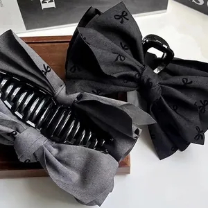 Large fabric bow hair claw clips in black and grey with delicate butterfly patterns