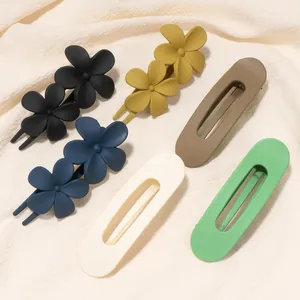 Detalle de pinzas para el cabello mate con formas florales y geométricas en tela