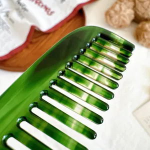 Gros plan d'un peigne à cheveux en acétate marbré vert avec de larges dents